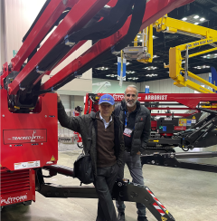 Two workers with a platform basket lift in the shop